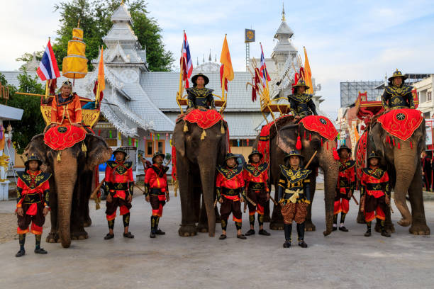 Lampang, Thailand - December 2, 2023: Traditional ceremony with elephants and Thai soldiers dressed in the Royal costume celebrating the former King Mengrai of Lanna.