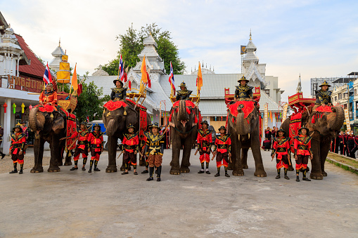 Lampang, Thailand - December 2, 2023: Traditional ceremony with elephants and Thai soldiers dressed in the Royal costume celebrating the former King Mengrai of Lanna.