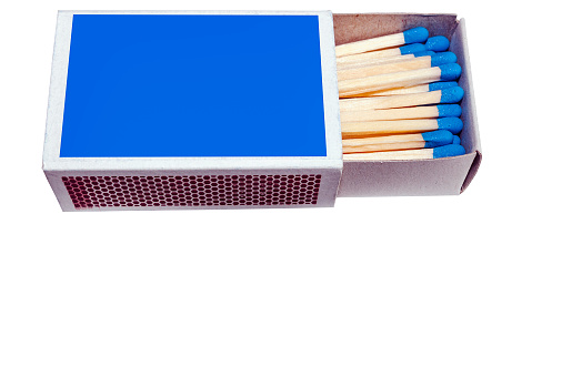 Close-up of matchsticks in the box, on blue background.