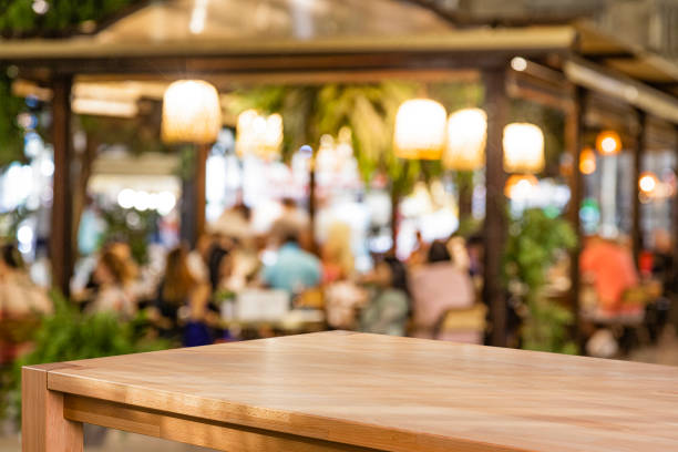 Empty table with defocused night street restaurant at background Empty table with defocused night street restaurant at background pub table top view stock pictures, royalty-free photos & images