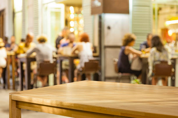 Empty table with defocused night street restaurant at background
