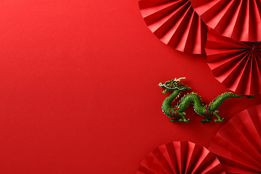 Chinese New Year 2024 year of the dragon. Chinese zodiac symbol with folding paper fans on red background.