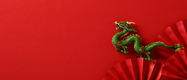 2024 Chinese New Year banner template, Year of the dragon. Flat lay folding paper fans and dragon on red background.