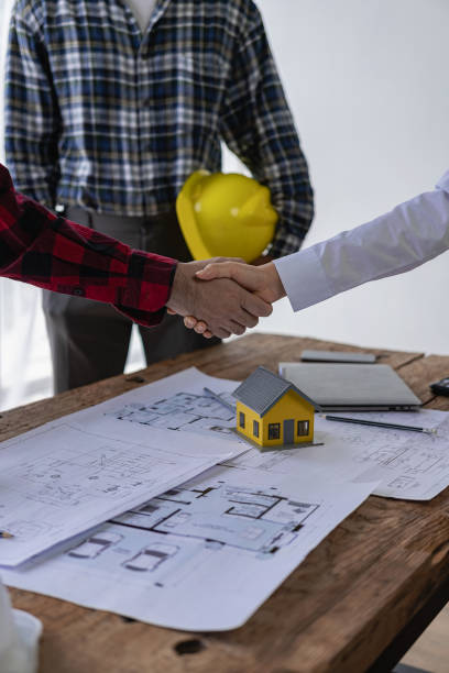 istock Architect engineer holding hands next to window, business teamwork, architect and engineer, construction workers holding hands while working and cooperation concept after completing agreement. 1871951528
