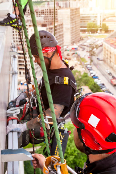 istock Industrial mountaineering worker hangs over residential building 1871975244