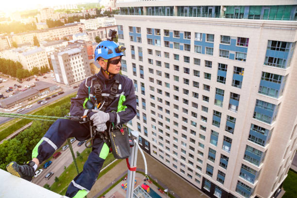 istock Industrial mountaineering worker hangs over residential building 1871975245