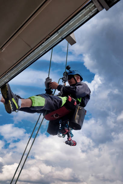 istock Industrial mountaineering worker hangs over residential building 1871975250