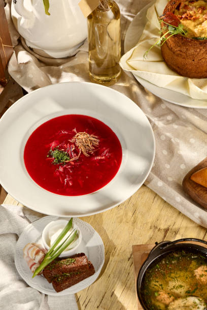 istock Borscht composition on a table with pork belly, garlic, and black bread, a Slavic dining staple 1871989314