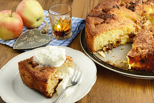 A apple pie with a leaf design on top. The pie is cut into pieces and is on a white plate