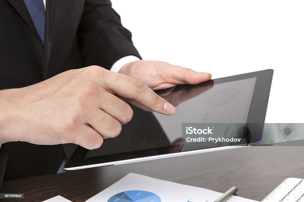 Empresario sosteniendo una tableta en la mesa con gráficos - Foto de stock de Adulto libre de derechos