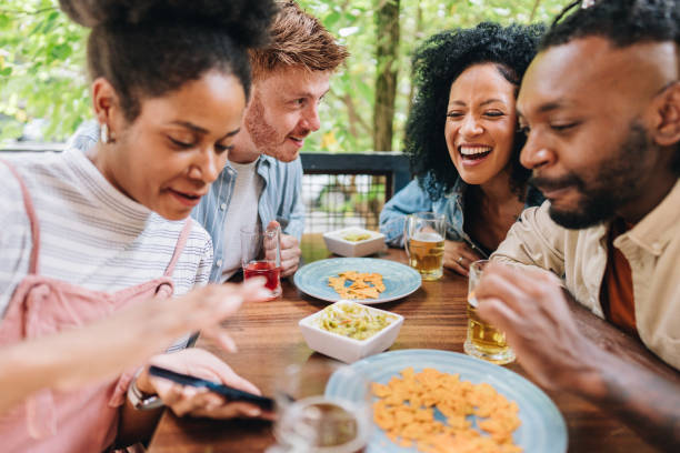 istock Friends using mobile phone at bar or restaurant 1872004424
