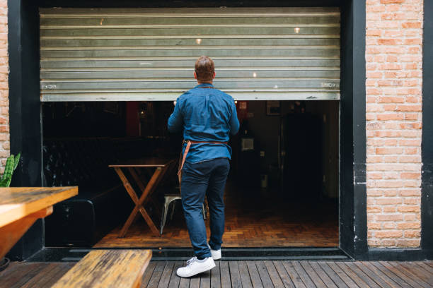 owner man opening or closing his coffee shop - puerta negocio fotografías e imágenes de stock
