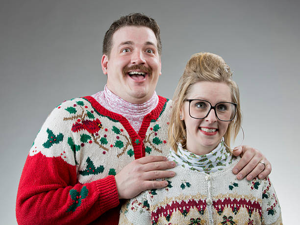 Awkward Christmas Photo A couple of people dressed in their best ugly sweater, posing for a christmas photo. christmas sweater stock pictures, royalty-free photos & images