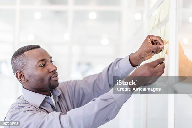 African Businessman Sticking Post Its Stock Photo - Download Image Now - Business, Ideas, Office