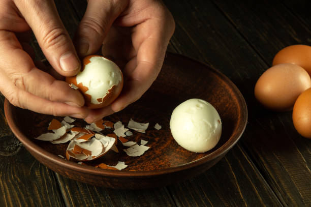 istock Close-up of a man hands holding a boiled egg. Peeling eggs from the shell. Cooking a delicious dinner with boiled eggs. 1872028182