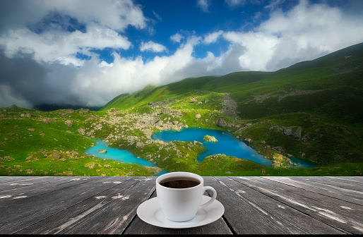Close up white coffee cup on wood table and view of nature background.