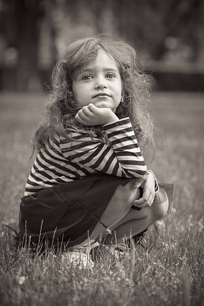 istock Little girl sitting in grass 187204147