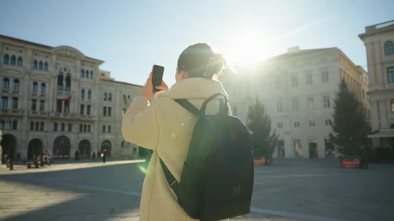 SLO MO Young Female Tourist with Backpack Using Smartphone to Take Pictures of Trieste City Hall on Sunny Day