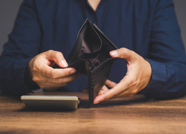 istock Close-up of hands opening an empty wallet while sitting at the table 1872057006