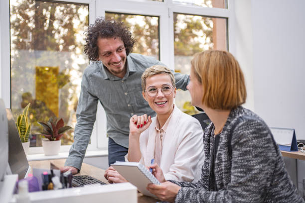 istock Three coworkers working together on a computer at the office 1872066281