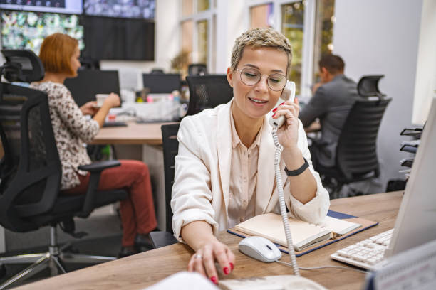 istock Busy businesswoman using corporate telephone while working at the office 1872067337