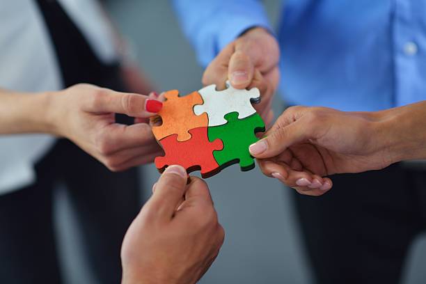 istock Group of business people assembling jigsaw puzzle 187207204