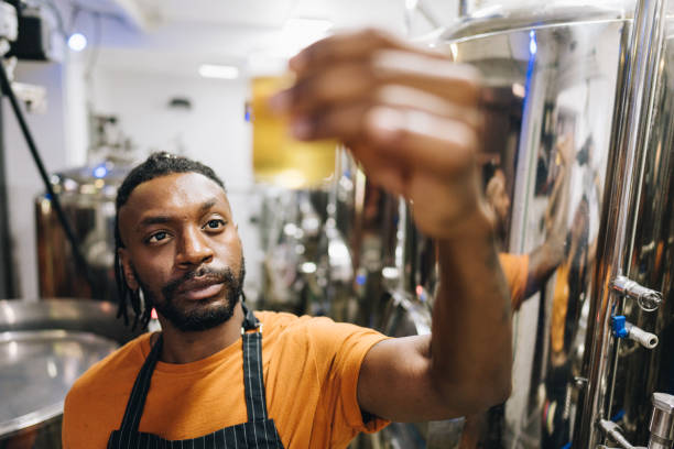 istock Quality controller mid adult man analyzing a glass of beer at brewery 1872076740