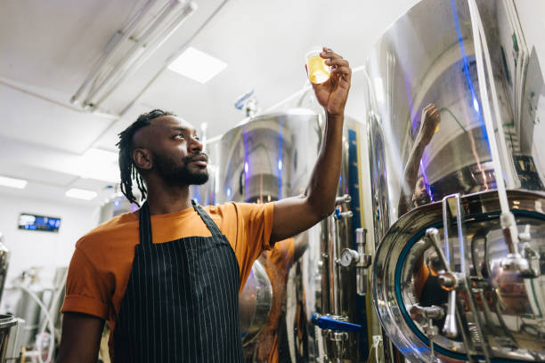 istock Quality controller mid adult man analyzing a glass of beer at brewery 1872076749