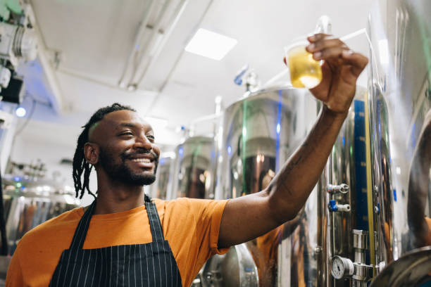 istock Quality controller mid adult man analyzing a glass of beer at brewery 1872076761