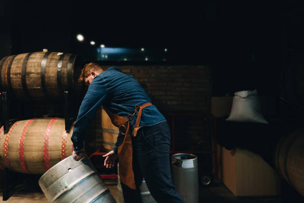 istock Man picking up a barrel of beer at microbrewery 1872077279