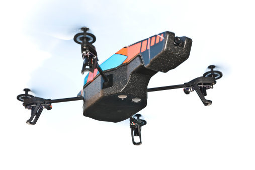 A quadricopter drone. The toy features two cameras (front and bottom). On white cloud sky.