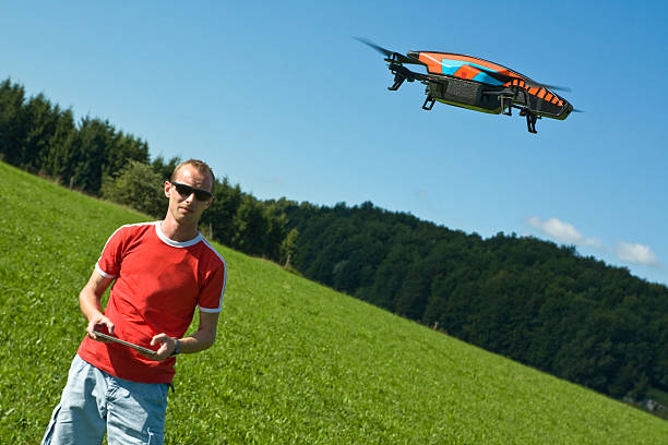 istock Man standing in an open field and flying a drone 187209802