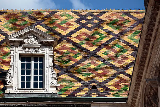 Traditional ceramic roof tiles on a Government building in Dijon, Burgundy, France.  The patterned roof displays are unique to the Dijon and Beaune area of Burgundy and can be seen on many historic Government and religious buildings.  Alternative version shown below: