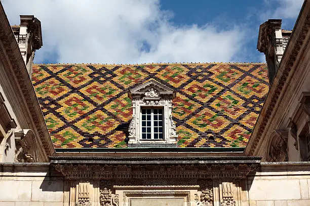 Traditional ceramic roof tiles on a Government building in Dijon, Burgundy, France.  The patterned roof displays are unique to the Dijon and Beaune area of Burgundy and can be seen on many historic Government and religious buildings.  Alternative version shown below: