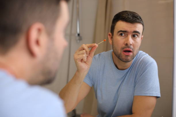 man finding some blood on ear cotton swabs - cotton swab audio imagens e fotografias de stock