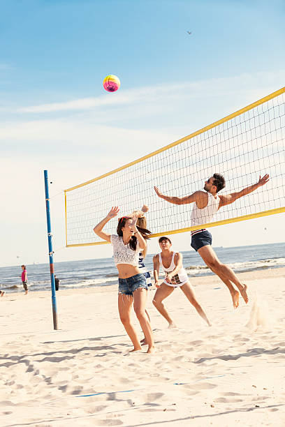 amigos jugando voleibol de playa - vóleibol de playa fotografías e imágenes de stock