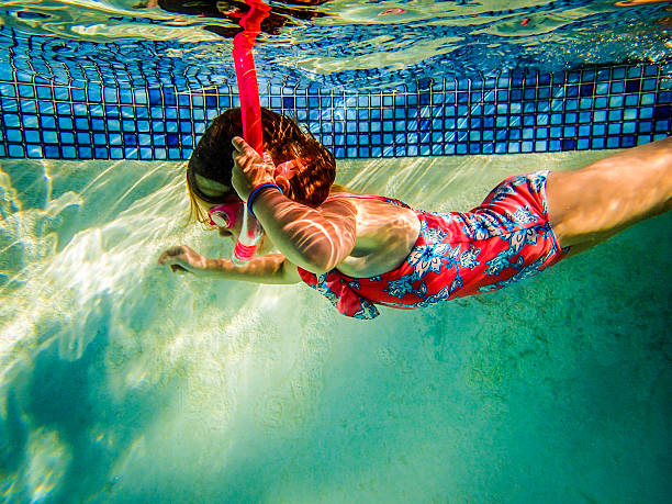 молодые красочные девочка, плавание в бассейне - directly below looking women human head стоковые фото и изображения