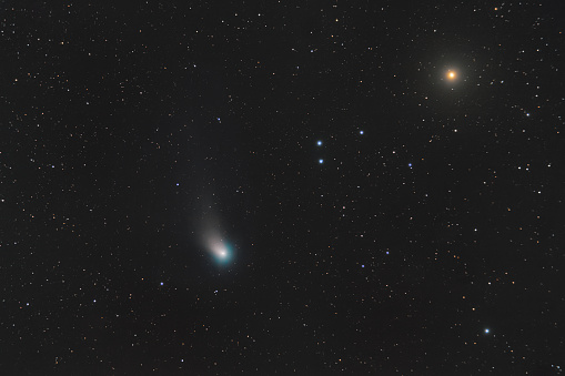 Soft focus. Real photo of space objects. Lots of dot images of stars across the entire image field. Comet c2022 e3 ztf flies against the background of stars in outer space.