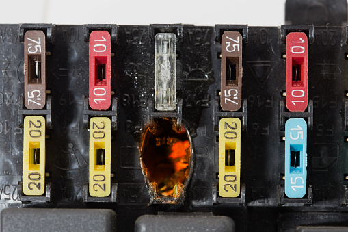 Burnt electrical contacts in the car fuse box. On the body of the unit, the designations of electrical circuits controlled by fuses are applied.