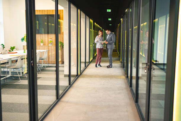 istock Two business colleagues in the hallway reading an important document 1872169554