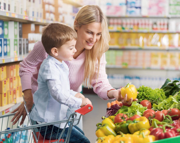 istock Young mother buying fresh vegetables with her son 1872184160