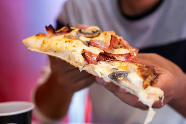 istock Unknown individual savoring piping-hot pizza. 1872185710