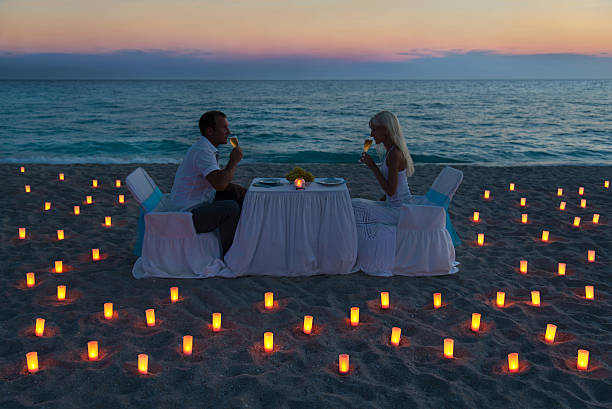 istock lovers couple share a romantic dinner on sea beach 187219450