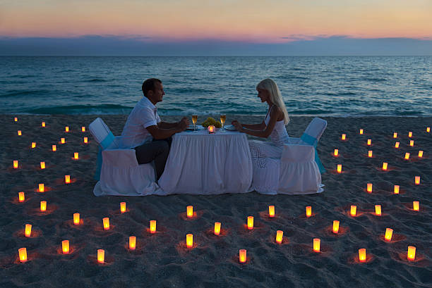 istock Couple having dinner at beach surrounded by candles 187219453