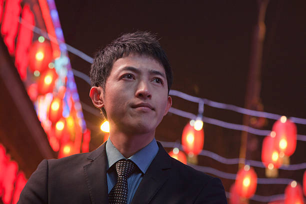 Businessman standing on the street, red lanterns on the background