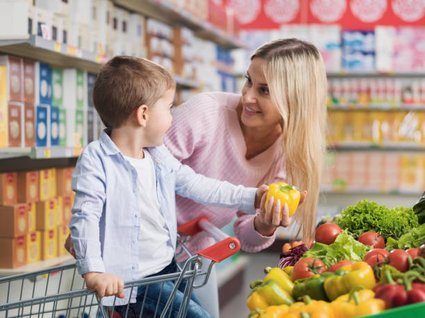 istock Young mother buying fresh vegetables with her son 1872196797