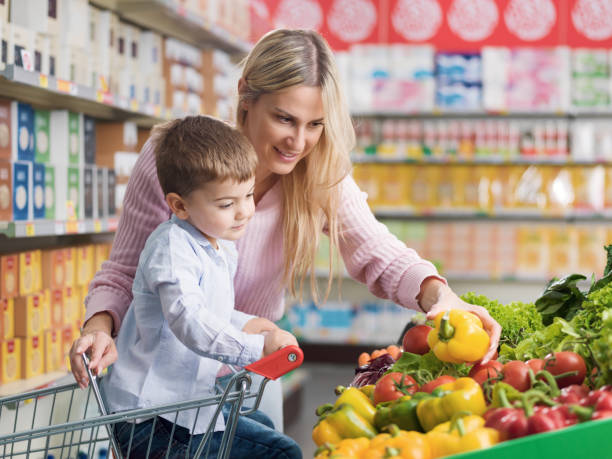 istock Young mother buying fresh vegetables with her son 1872198412