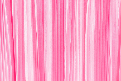 delicate chic textile background of pink color. pleats of chiffon or silk fabric. Abstract background for design. A copy space.