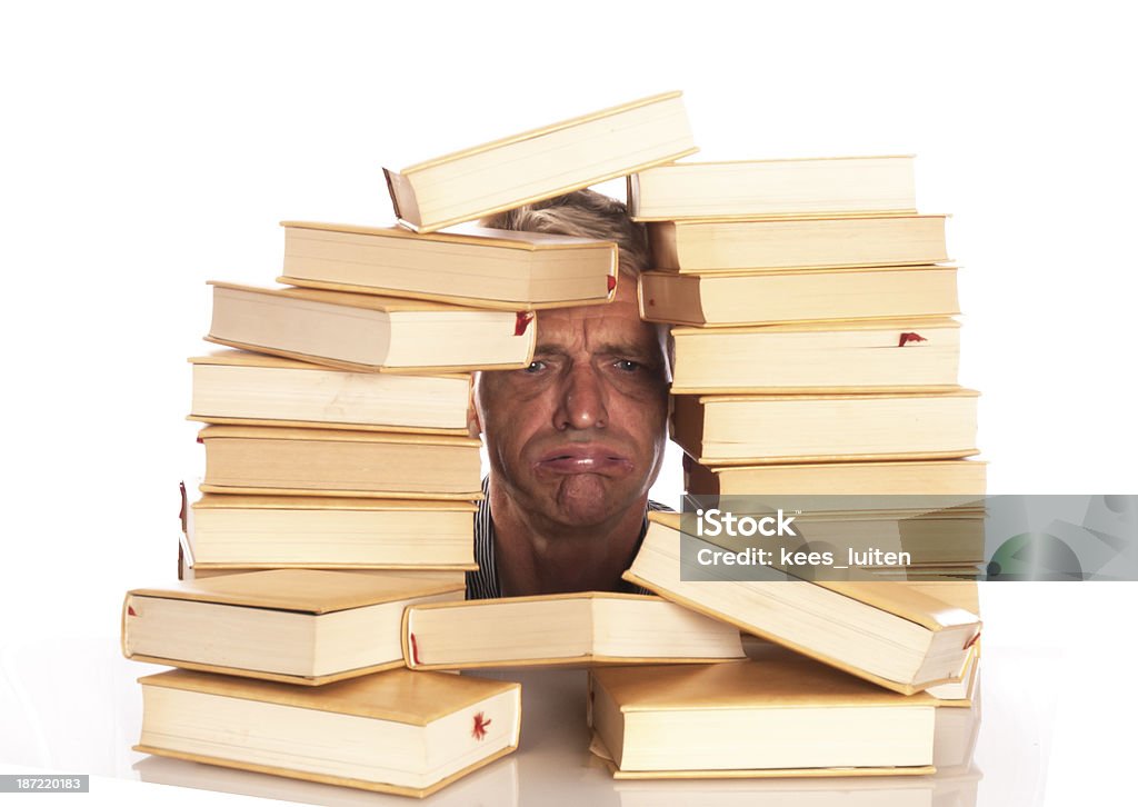 Uomo con la testa tra i libri - Foto stock royalty-free di Adulto