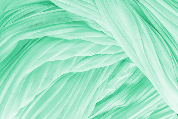 istock Delicate air waves of mint, green colored silk or chiffon fabric. Layout for design. Background image for holiday decor. A copy space 1872202073